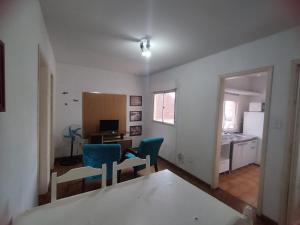 a living room with two blue chairs and a kitchen at Vitrine apart. Hotel in Bagé