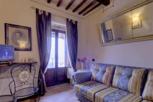 a living room with a couch and a tv at Country House Federico I in Sassoferrato