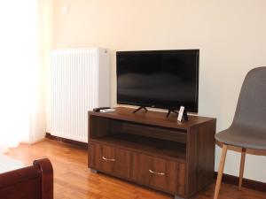 a flat screen tv sitting on top of a wooden entertainment center at Ήσυχο και κεντρικό διαμέρισμα in Larisa