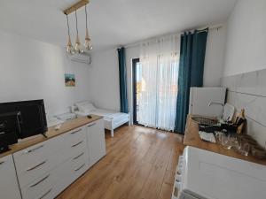 a kitchen with white cabinets and a large window at White apartments in Ulcinj