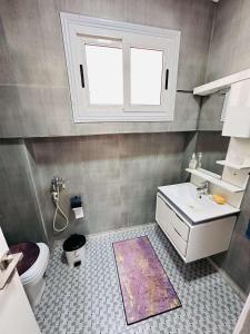 a bathroom with a sink and a toilet and a window at Appartement Berramdane in Aïn El Turk