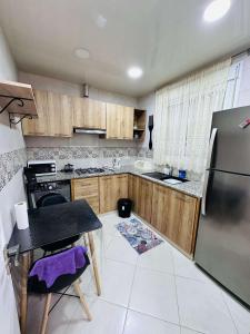 a kitchen with wooden cabinets and a stainless steel refrigerator at Appartement Berramdane in Aïn El Turk