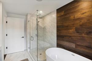 une salle de bain avec baignoire et douche en verre dans l'établissement Natures Way: 4 br, fireplace, a/c, hot tub, community summer pool, garage, à Stowe Fork