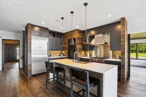 une cuisine avec des armoires noires et un îlot de cuisine avec des chaises dans l'établissement Natures Way: 4 br, fireplace, a/c, hot tub, community summer pool, garage, à Stowe Fork 24 autres photos