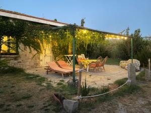 a patio with a table and chairs under a pergola at Old cowshed from the '30 in Santa Maria Coghinas