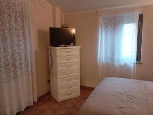 a bedroom with a bed and a television on a dresser at Agriturismo i Due Mori in Treia