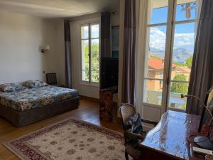 a bedroom with a bed and a television and a balcony at Magnifique villa pieds dans l eau Saint Jean Cap Ferrat in Saint-Jean-Cap-Ferrat