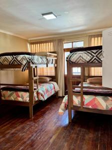 a room with three bunk beds in a house at Santa Teresa Alley Hostel in Sucre