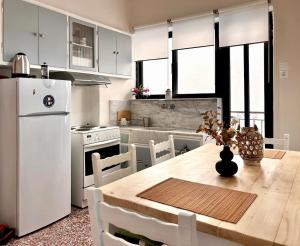 a kitchen with a wooden table and a white refrigerator at Ναϊάδες in Konístrai