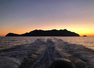 a view from the back of a boat in the water at sunset at Cabina Da Mare in Marettimo