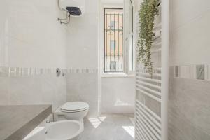 Un baño blanco con inodoro y ventana. en Modern&Elegant Double suite Flat - 15 min Duomo, en Milán 32 fotos más
