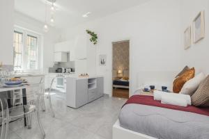 Una cocina blanca y una sala de estar con una cama en una habitación. en Modern&Elegant Double suite Flat - 15 min Duomo, en Milán