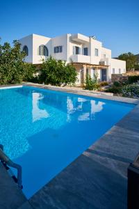 a villa with a swimming pool in front of a house at La maison in Parikia