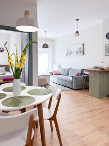 una sala de estar con una mesa con flores amarillas. en Apartament Mona Jeżyce, en Poznan
