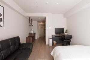 東京にあるLANG HOTEL Kameido - Vacation STAY 79042vのベッド、ソファ、テレビが備わる客室です。