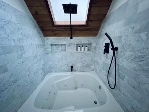 a white bath tub in a bathroom with a window at Brentwood Haus in Lake Arrowhead