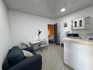 a living room with a blue couch and a kitchen at Hospedaje Bethel in Comayagua