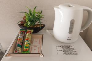 a table with a white vase and a box and a plant at LANG HOTEL Kameido - Vacation STAY 76836v in Tokyo