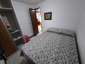 una piccola camera da letto con un letto in una stanza di Refúgio Souza a Florianópolis