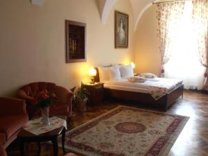 een slaapkamer met een bed, een bank en een stoel bij Gothic House in Sibiu