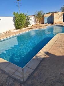 a large swimming pool with blue water at Residence Nour douz in Douz