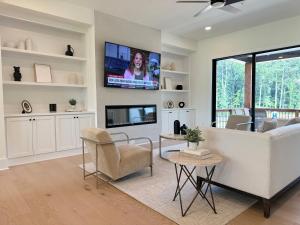 a living room with a couch and a tv at Executive 3BR Townhome Rooftop & Elevator Near Avalon in Alpharetta