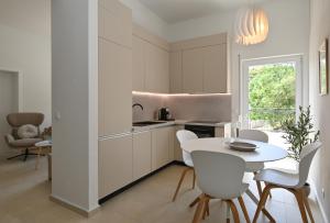 a kitchen with white cabinets and a table and chairs at Casa Dalmacija in Krvavica