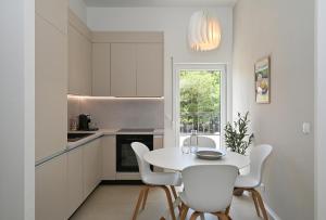 a white kitchen with a white table and chairs at Casa Dalmacija in Krvavica +16 photos
