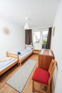a room with two beds and a chair and a window at Almádi64 in Balatonalmádi