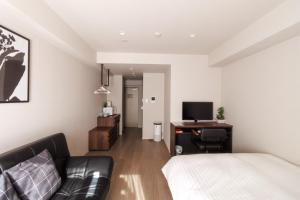 a bedroom with a bed and a desk with a television at LANG HOTEL Kameido - Vacation STAY 79080v in Tokyo