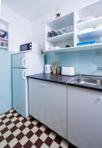 a kitchen with white cabinets and a checkered floor at Almádi64 in Balatonalmádi