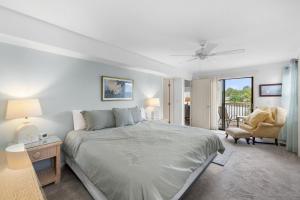 een slaapkamer met een groot bed en een stoel bij Oyster Catcher Oasis 3BR Villa Roof Top Balcony in Pawleys Island