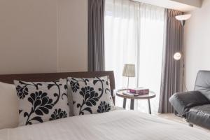 東京にあるLANG HOTEL Kameido - Vacation STAY 76961vのベッドとソファと窓のある寝室