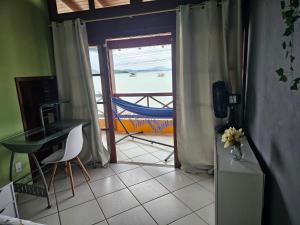 a room with a desk and a view of the ocean at Aspidiske in Governador Celso Ramos
