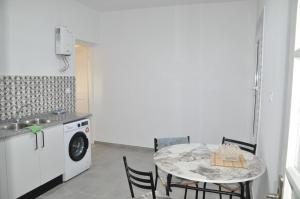 a kitchen with a table and a washing machine at Appartement neuf et meublé in Houmt Souk