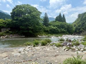a river with rocks and trees in the background at Riverside Glamping Nuts - Vacation STAY 78014v in Yamakami