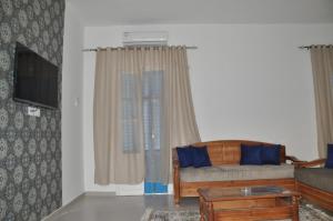 a living room with a couch and a table at Appartement neuf et meublé in Houmt Souk