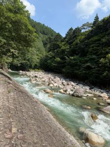 a river with rocks and trees on a dirt road at Riverside Glamping Nuts - Vacation STAY 78016v in Yamakami