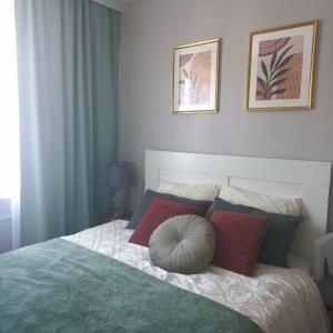 a bedroom with a large bed with red and blue pillows at Narva Vibe Apartment in Narva