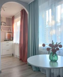 a room with a table with a vase of flowers on it at Narva Vibe Apartment in Narva