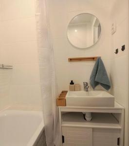 a bathroom with a sink and a mirror and a tub at Narva Vibe Apartment in Narva