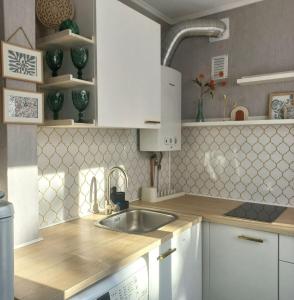 a kitchen with white cabinets and a sink at Narva Vibe Apartment in Narva +6 photos