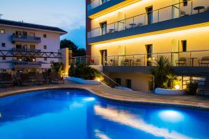a hotel with a swimming pool in front of a building at Petit Palau - Adults Only in Blanes