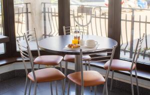 ein Tisch mit Stühlen und einem Teller mit Essen darauf in der Unterkunft Hotel Kert FREE PARKING in Riga