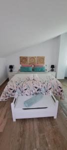 a bedroom with a white bed with a wooden floor at Vivienda Rural Sentirte 1 Centro de Aracena in Aracena