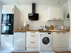 a kitchen with a washing machine and a washer at Vivez le confort moderne pour 4 personnes in Châlons-en-Champagne +2 photos