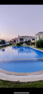 una grande piscina blu davanti a una casa di Villa Tego a Çeşme Altre 5 foto