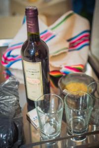 a bottle of wine and two glasses on a table at Casa Erick in San Antonio