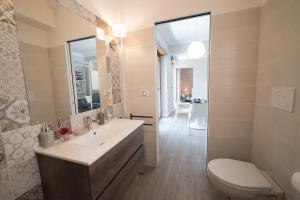 Un baño con lavabo, inodoro y espejo. en VaticanRhome II, en Roma 13 fotos más
