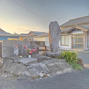 a stone grave yard with flowers in front of a building at Kaen - Vacation STAY 19037 in Aso